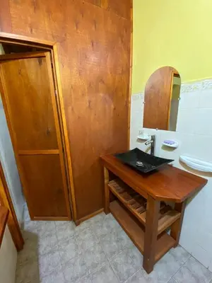 a bathroom with a wooden table and a sink at Paseo por las Nubes in Santa Rosa de Calamuchita
