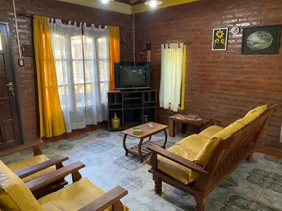 a living room with a couch and a tv at Paseo por las Nubes in Santa Rosa de Calamuchita