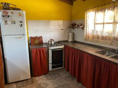 a kitchen with a white refrigerator and a stove at Paseo por las Nubes in Santa Rosa de Calamuchita