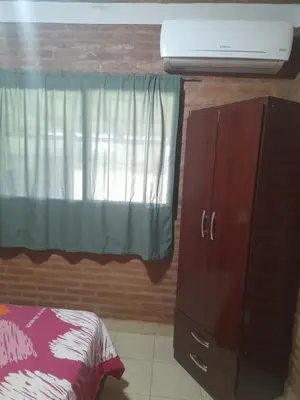 a bedroom with a bed and a dresser and a window at Cabañas Lo De Elias in San Lorenzo