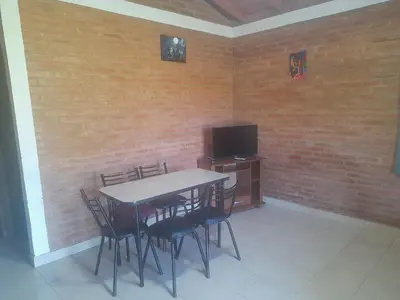 a dining room with a table and chairs and a tv at Cabañas Lo De Elias in San Lorenzo