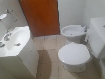 a white bathroom with a toilet and a sink at Cabañas Lo De Elias in San Lorenzo