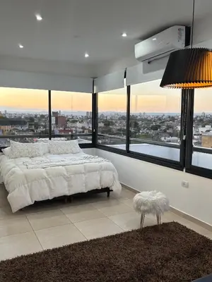 a bedroom with a large bed and large windows at Luminosos y modernos apartamentos con cochera techada in Cordoba
