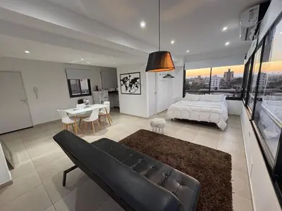 a large bedroom with a bed and a dining table at Luminosos y modernos apartamentos con cochera techada in Cordoba