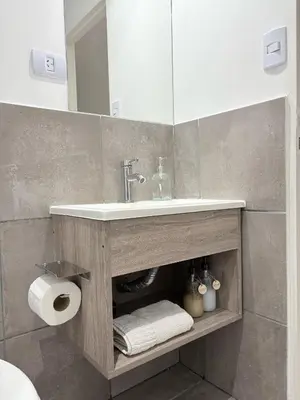 a bathroom with a sink and a mirror at Luminosos y modernos apartamentos con cochera techada in Cordoba
