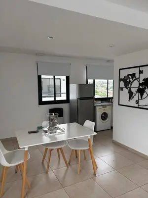 a kitchen with a white table and white chairs at Luminosos y modernos apartamentos con cochera techada in Cordoba