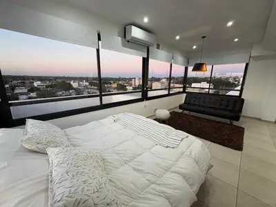 a bedroom with a large white bed and a couch at Luminosos y modernos apartamentos con cochera techada in Cordoba