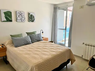 a bedroom with a bed and a large window at Disfruta Córdoba en un departamento premium! in Cordoba