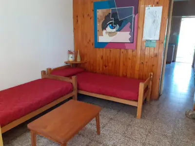 a living room with two beds and a table at Casa Abuela Tere in Santa Rosa de Calamuchita