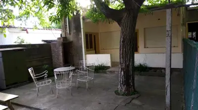 a group of chairs and a table next to a tree at Casa Abuela Tere in Santa Rosa de Calamuchita