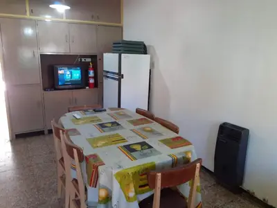a kitchen with a table with chairs and a refrigerator at Casa Abuela Tere in Santa Rosa de Calamuchita