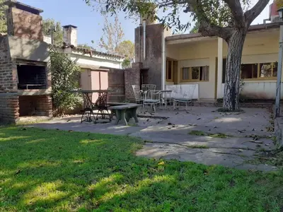 a patio with a table and chairs in front of a house at Casa Abuela Tere in Santa Rosa de Calamuchita