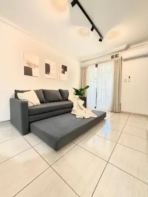 a living room with a gray couch in a white room at Nueva Córdoba - Ituzaingó Siglo 21- Sanatorio Allende in Cordoba