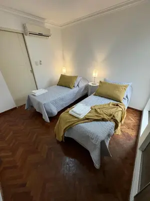 two beds sitting in a room with wood floors at Nueva Córdoba - Ituzaingó Siglo 21- Sanatorio Allende in Cordoba
