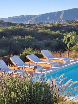 a row of lounge chairs next to a swimming pool at Ventura 2 in Estancia Vieja
