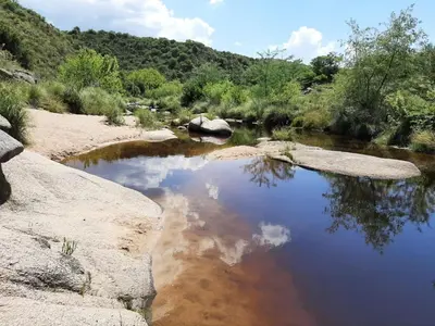 a river with rocks in the middle of a field at Ventura 2 in Estancia Vieja