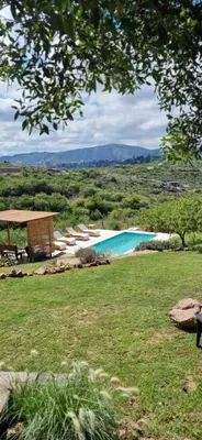 a swimming pool in a field with a grass field at Ventura 2 in Estancia Vieja