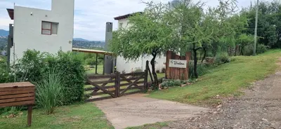 a house with a wooden gate and a fence at Ventura 2 in Estancia Vieja