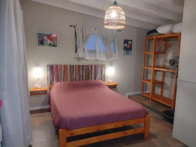 a bedroom with a bed and a chandelier at El Colibrí de los Molles in Los Molles