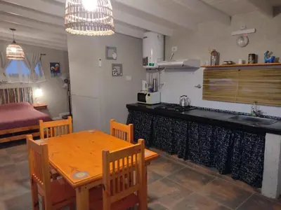 a kitchen and dining room with a table and a sink at El Colibrí de los Molles in Los Molles