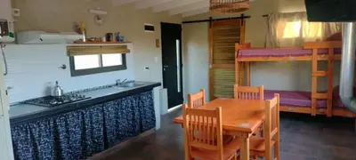 a kitchen and dining room with a table and a bunk bed at El Colibrí de los Molles in Los Molles
