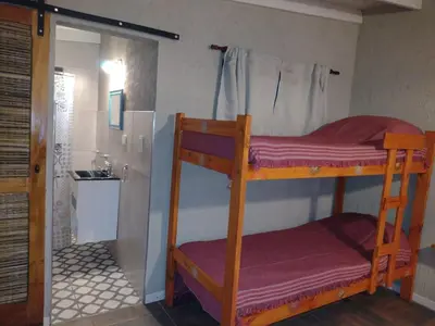 a room with two bunk beds and a shower at El Colibrí de los Molles in Los Molles