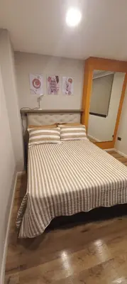 a bedroom with a bed with a striped comforter at Depto Alta Gracia, 1 cuadra del centro- 75m2 in Alta Gracia