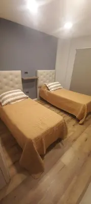 two beds in a room with wooden floors at Depto Alta Gracia, 1 cuadra del centro- 75m2 in Alta Gracia