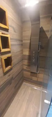a bathroom with a shower with wooden walls at Depto Alta Gracia, 1 cuadra del centro- 75m2 in Alta Gracia
