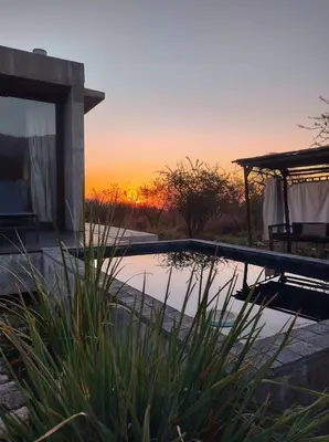 a swimming pool with a sunset in the background at La Singladura in La Población