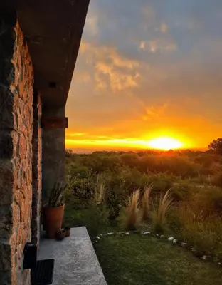a sunset from the porch of a house with the sun setting at La Singladura in La Población