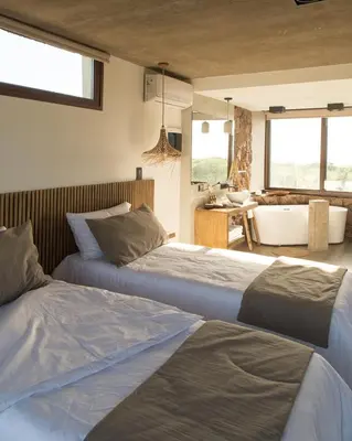 a bedroom with two beds and a bathroom with a tub at La Singladura in La Población