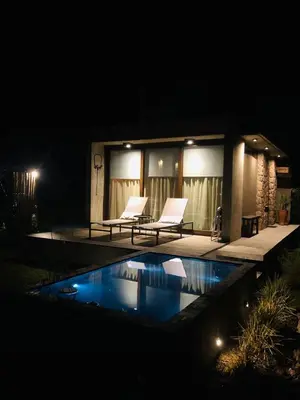a house with two chairs and a swimming pool at night at La Singladura in La Población