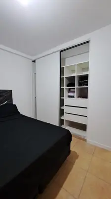 a bedroom with a black bed and a closet at Cordoba Costanera 2 dormitorios con estacionamiento in Cordoba