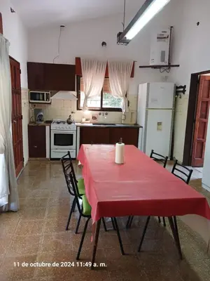 a kitchen with a table with a red table cloth on it at CASA FRENTE AL RIO CON PILETA PRIVADA ESTANCIA VIEJA Carlos Paz in Villa Carlos Paz