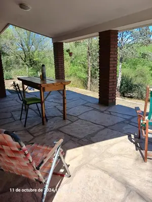 a patio with a table and chairs on a patio at CASA FRENTE AL RIO CON PILETA PRIVADA ESTANCIA VIEJA Carlos Paz in Villa Carlos Paz