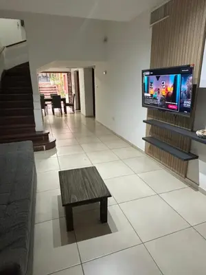 a living room with a couch and a tv on a wall at Casa en Nueva Córdoba con Patio y Asador in Cordoba