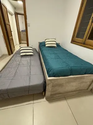 two beds sitting next to each other in a room at Casa en Nueva Córdoba con Patio y Asador in Cordoba