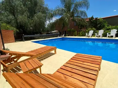 a swimming pool with a picnic table and two chairs at La Cantata in Merlo
