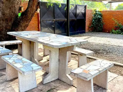 a stone picnic table and benches in a park at La Cantata in Merlo