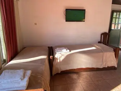 two beds in a room with a tv on the wall at La Cantata in Merlo