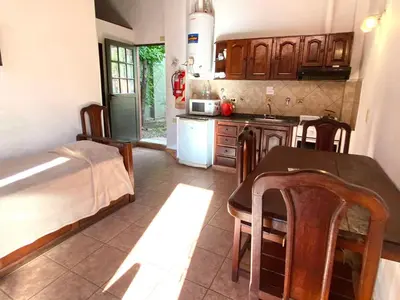 a kitchen with a table and a bed in a room at La Cantata in Merlo