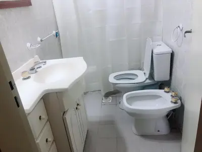 a white bathroom with a toilet and a sink at Merlindo Alojamiento in El Rincón