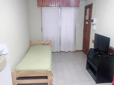 a small room with a bed and a television at Merlindo Alojamiento in El Rincón