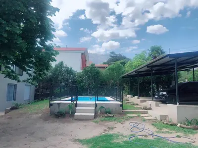 a swimming pool in a yard next to a building at Merlindo Alojamiento in El Rincón