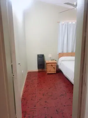 a bedroom with a bed and a red carpet at Merlindo Alojamiento in El Rincón