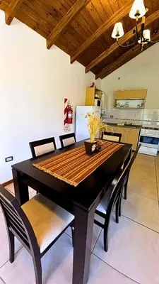a dining room with a black table and chairs at Cabañas El Principio in Villa Cura Brochero