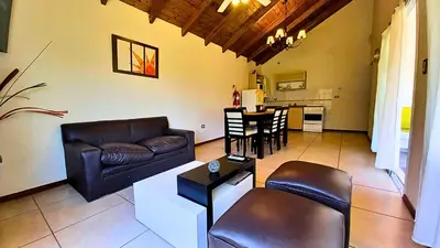 a living room with a couch and a table at Cabañas El Principio in Villa Cura Brochero