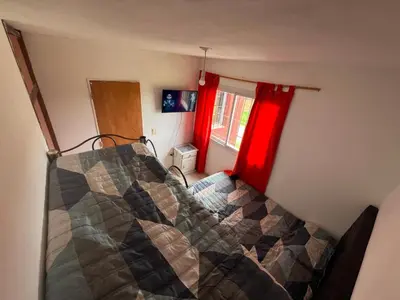 a bedroom with a bed and a red window at La Armonía in Potrero de Garay