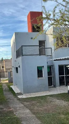 a white building with green windows on the side of it at La Armonía in Potrero de Garay